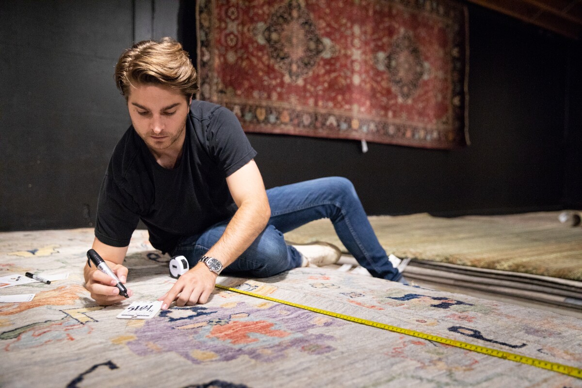 Den Cralle looking at farmville rugs in Green Front Furniture showroom