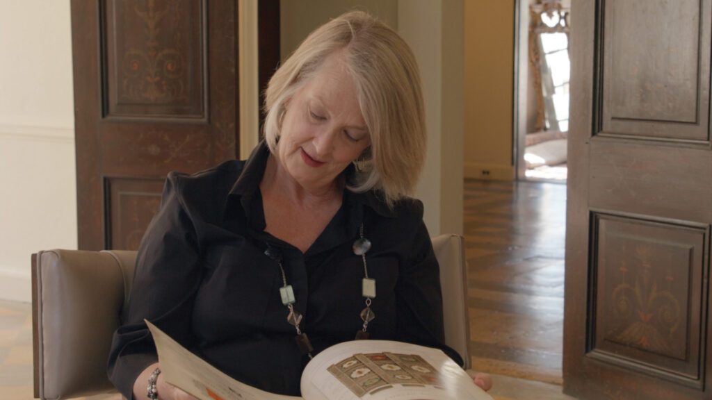 Woman reading a book about diverse design and Spanish inspired traditional furniture from a curated furniture selection