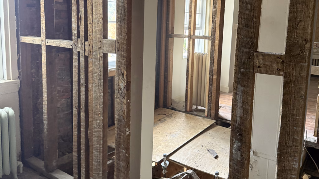Historic home renovation with exposed framing and window restoration in progress